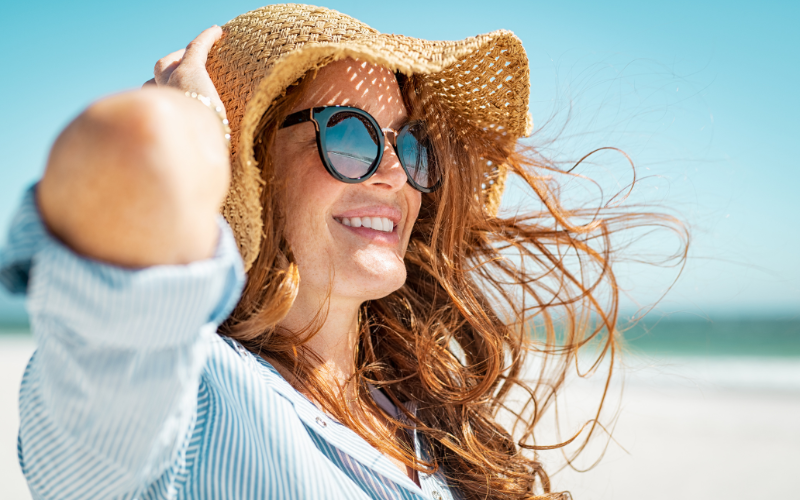 Woman in Sunglasses and Hat on the Beach
